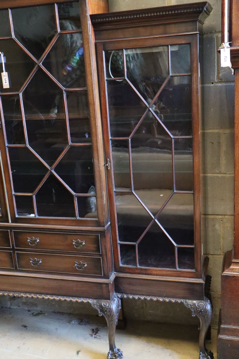 A Chippendale style mahogany breakfront display cabinet fitted four astragal-glazed doors, on cabriole legs with claw and ball feet,